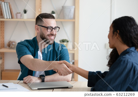 Smiling hr manager shaking hands with african american job applicant. 63212269
