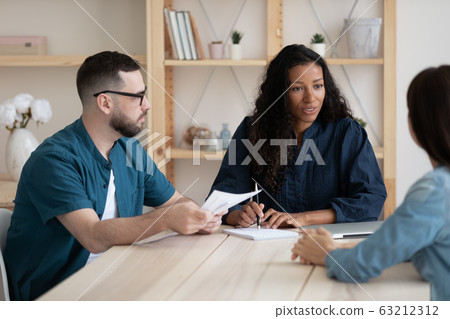 Focused young african american female supervisor holding meeting with teammates. 63212312