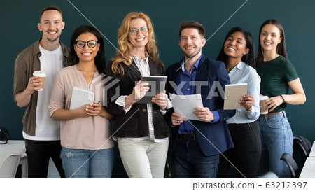 Standing in row indoors smiling for camera multiethnic corporate staff Standing in row indoors smiling for camera multiethnic corporate staff 63212397