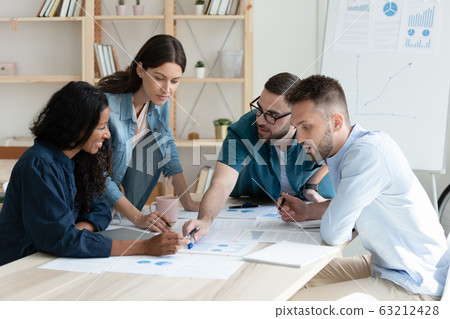 Focused millennial multiracial coworkers discussing accounting reports. 63212428
