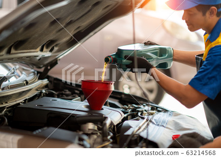 Mechanician changing car wheel in auto repair shop Mechanician changing car wheel in auto repair shop 63214568