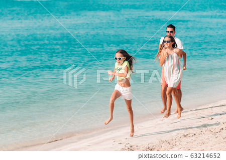 Happy beautiful family on a tropical beach vacation Happy beautiful family on a tropical beach vacation 63214652