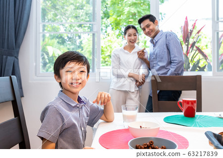 Happy Asian family in dining room, boy son sitting 63217839