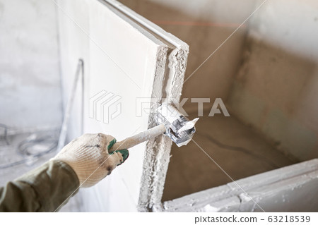 Tools on Gypsum plate. Construction of internal walls in the apartment using a plaster concrete plate with groove ridge. Tools on Gypsum plate. Construction of internal walls in the apartment using a plaster concrete plate with groove ridge. 63218539