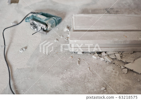 An electric jigsaw is lying on the floor. Gypsum plate. Construction of internal walls in the apartment using a plaster concrete plate with groove ridge. tongue-and-groove gypsum blocks An electric jigsaw is lying on the floor. Gypsum plate. Construction of internal walls in the apartment using a plaster concrete plate with groove ridge. tongue-and-groove gypsum blocks 63218575