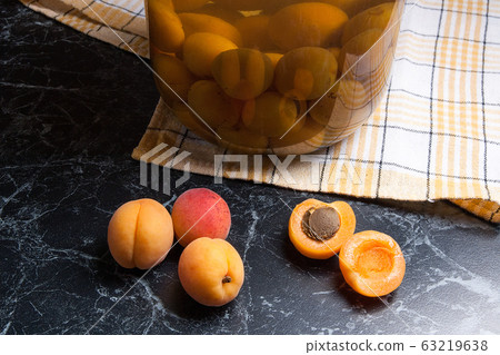 Juicy harvested apricots and big glass jar with Juicy harvested apricots and big glass jar with 63219638