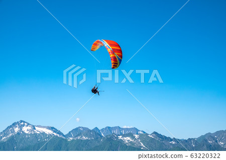 Red paraglider in blue clear sky over the Green Mountains 63220322