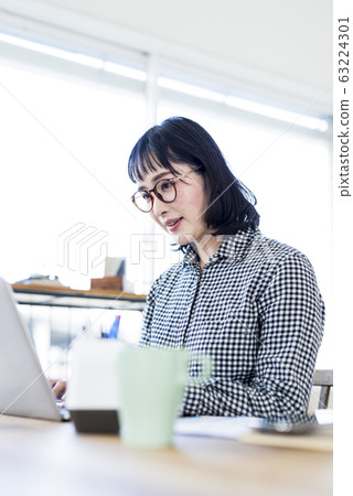 A woman working at the window seat A woman working at the window seat 63224301