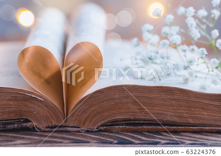 Old opened book, heart shaped paper sheets,fresh 63224376