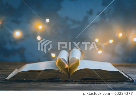 Old opened book, heart shaped paper sheets, dark 63224377