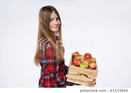 Teen girl with apples and pears in a box Teen girl with apples and pears in a box 63224898
