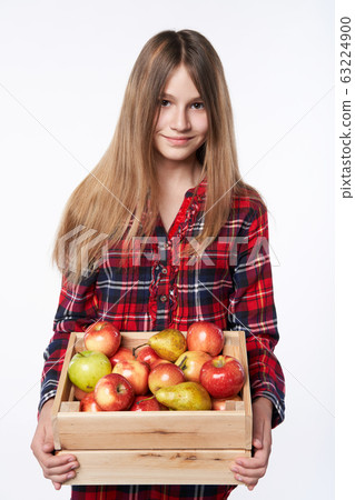 Teen girl with apples and pears in a box 63224900