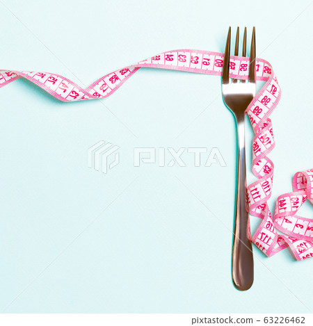 Fork and curled measuring tape are on blue Fork and curled measuring tape are on blue 63226462