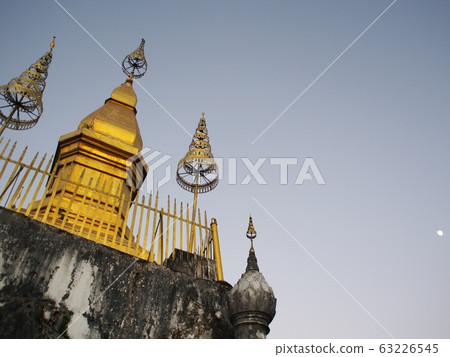 reflect sunlight at the buddhism golden stupa: PHU-SI or PHOUSI monument under twilight sky at evening time in LUANG PRABANG, LAOS 63226545