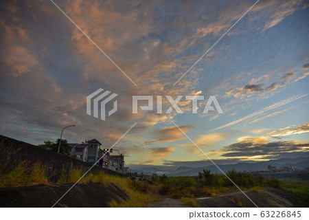 太陽沿著天際線升起，美麗的天空在空中。 63226845