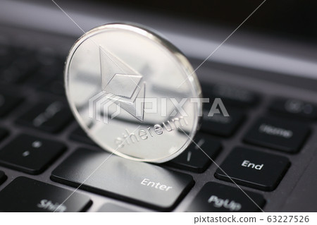 Silver ethereum coin is lying on laptop 63227526