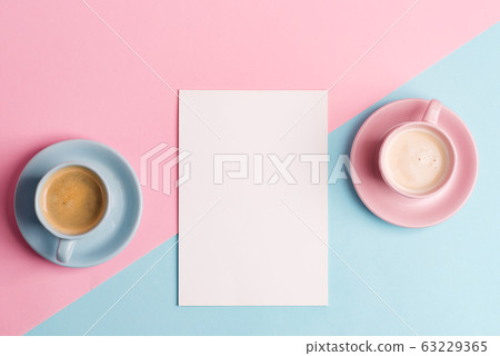 Creative pastel blue pink background with two ceramic cups of freshly brewed coffee drink and paper sheet. 63229365