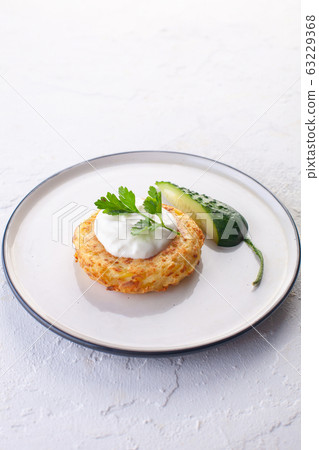 potato pancakes with sour cream , fresh cucumber 63229368