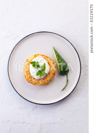 potato pancakes with sour cream , fresh cucumber 63229370