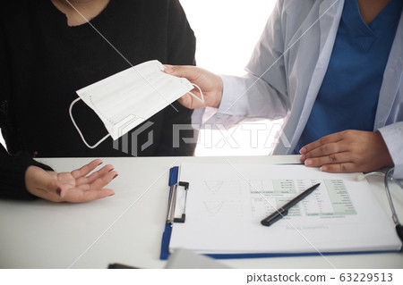 Female medicine doctor working on table with consulting patient 63229513
