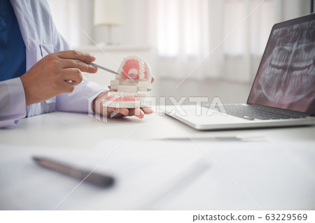 Female Dentist working in office 63229569