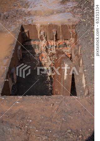 Dirty water and garbage get into the gutter. Dirty water and garbage get into the gutter. 63231334