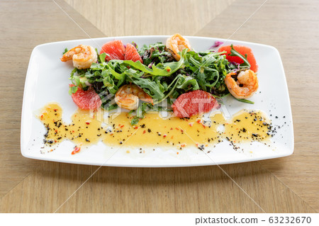 Fresh salad with grilled shrimps, slice grapefruit and arugula salad and spicy fried prawns. Restaurant menu, natural and organic food concept. Fresh salad with grilled shrimps, slice grapefruit and arugula salad and spicy fried prawns. Restaurant menu, natural and organic food concept. 63232670
