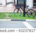 Bicycle top tube is securely chained, by chain link and lock, to the metal lamp post in the garden 63237817