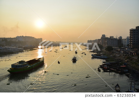 Dhaka in Bangladesh Beautiful sunrise and old cityscape Passenger ship that stops along the Brigonga River Large and small boats crossing the river 63238034