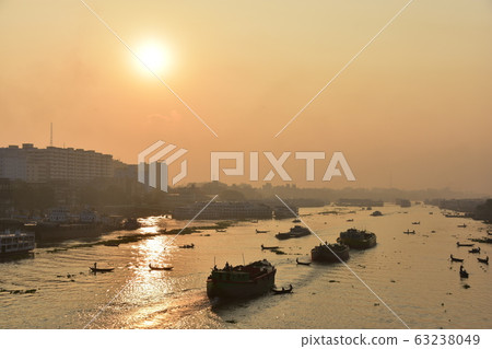 Dhaka in Bangladesh Beautiful sunrise and old cityscape Passenger ship that stops along the Brigonga River Large and small boats crossing the river 63238049