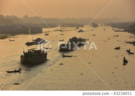 Dhaka in Bangladesh Beautiful sunrise and old cityscape Passenger ship that stops along the Brigonga River Large and small boats crossing the river 63238051