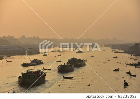 Dhaka in Bangladesh Beautiful sunrise and old cityscape Passenger ship that stops along the Brigonga River Large and small boats crossing the river 63238052