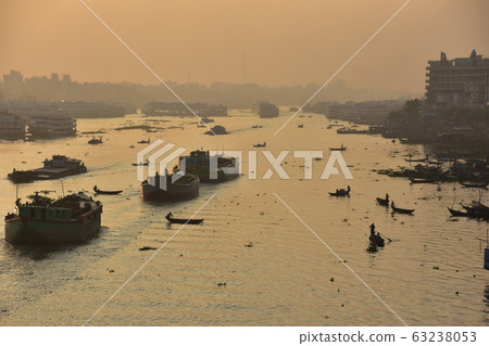 Dhaka in Bangladesh Beautiful sunrise and old cityscape Passenger ship that stops along the Brigonga River Large and small boats crossing the river 63238053