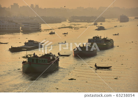 孟加拉國的達卡美麗的日出和古老的城市景觀沿著Brigonga河停靠的客船大大小小的小船越過河 63238054
