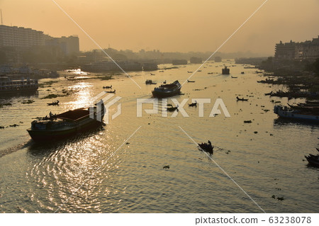 Dhaka in Bangladesh Beautiful sunrise and old cityscape Passenger ship that stops along the Brigonga River Large and small boats crossing the river 63238078