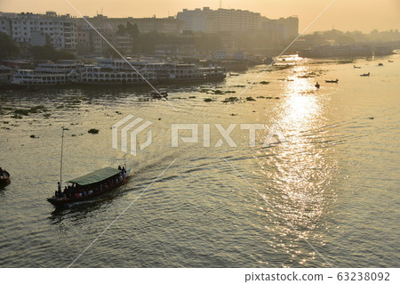 孟加拉國的達卡美麗的日出和古老的城市景觀沿著Brigonga河停靠的客船大大小小的小船越過河 孟加拉國的達卡美麗的日出和古老的城市景觀沿著Brigonga河停靠的客船大大小小的小船越過河 63238092