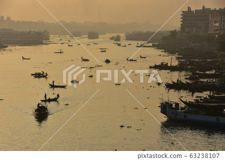Dhaka in Bangladesh Beautiful sunrise and old cityscape Passenger ship that stops along the Brigonga River Large and small boats crossing the river 63238107