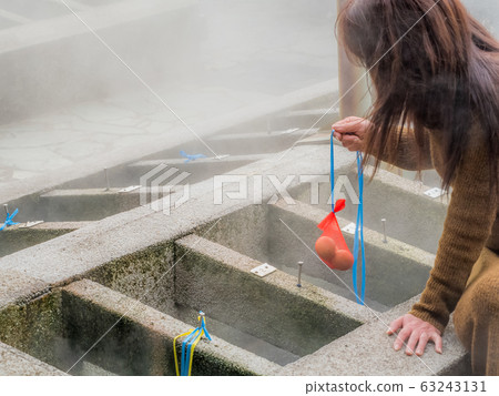 Woman enjoying a hot spring egg Woman enjoying a hot spring egg 63243131