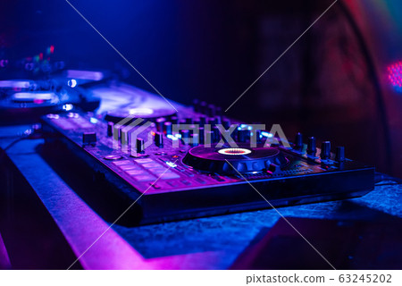 professional DJ mixer on table in nightclub professional DJ mixer on table in nightclub 63245202