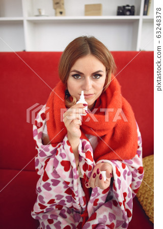 Woman sitting at home with a cold 63248378