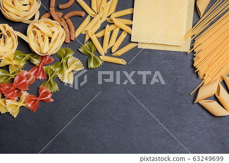 Different types of pasta on a black slate background with copy space. Top view Different types of pasta on a black slate background with copy space. Top view 63249699