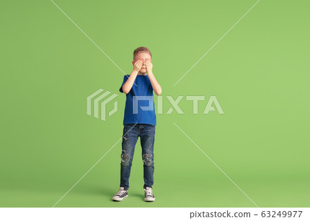 Happy boy playing and having fun on green studio background, emotions Happy boy playing and having fun on green studio background, emotions 63249977