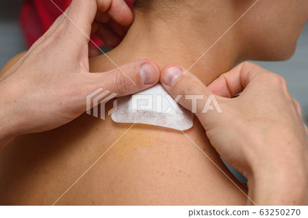 A medical patch is pasted on the wound A medical patch is pasted on the wound 63250270