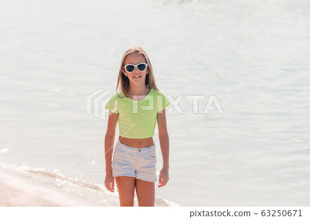 Adorable active little girl at beach during summer vacation 63250671