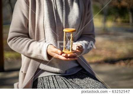 中年婦女舉行的沙漏 中年婦女舉行的沙漏 63252547