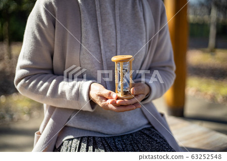 中年婦女舉行的沙漏 中年婦女舉行的沙漏 63252548