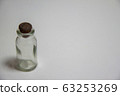 Small bottle placed on a white desk 63253269