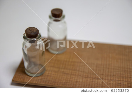 Small bottle placed on a white desk 63253270