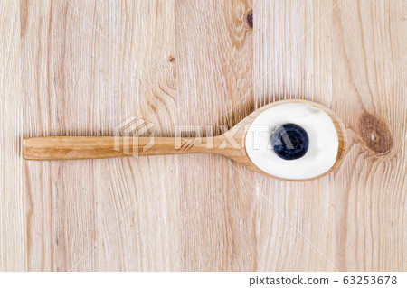 sour cream and blueberries in a spoon 63253678