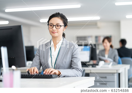 Middle-aged woman typing in the office 63254886